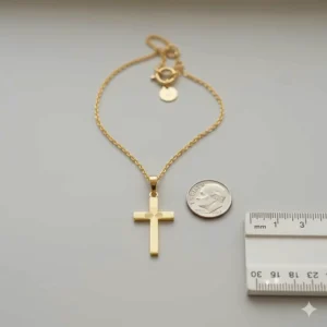 Size comparison of the luxurious 24k gold cross necklace next to a dime.