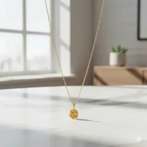 Close-up of a delicate 24k gold pendant necklace featuring a small, finely crafted charm.