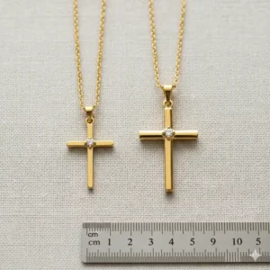 Scale image comparing the size of the small and medium 14k gold cross necklace options for women.