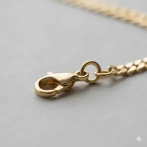 Secure lobster claw clasp and jump ring on the end of the premium 14k gold Figaro necklace.