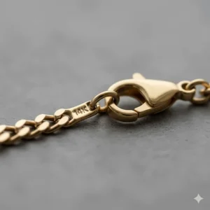 Close-up of the 14k gold purity stamp/hallmark stamped on the clasp or jump ring of the Figaro necklace.