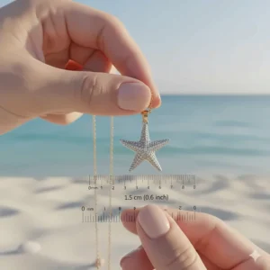 Hand holding a dainty starfish necklace pendant to show the true size and scale.