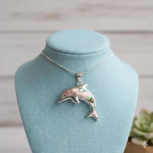 A unique mother-of-pearl dolphin necklace design, highlighting the iridescent shell inlay for a delicate ocean theme.