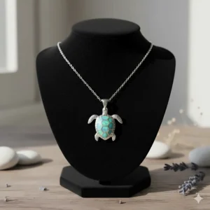 A stunning sterling silver sea turtle necklace with an opal inlay, elegantly displayed on a black velvet stand.