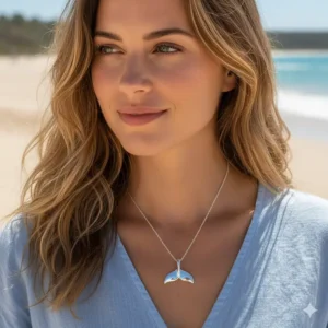 Detailed photo of the ocean-inspired whale tail necklace being worn by a model, showing the size and fit of the pendant and chain length.