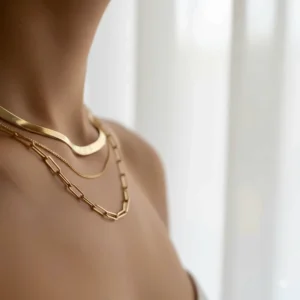 Mixing textures in everyday necklace gold layering with a snake chain and a paperclip link chain.