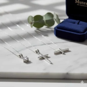 A collection of sterling silver pendant necklaces, including a diamond solitaire and cross designs, displayed on a marble surface.
