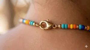 Close-up of the adjustable gold-plated lobster clasp on a colorful beaded necklace.