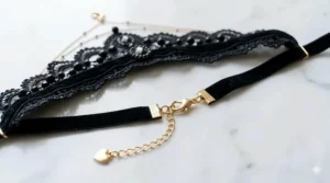 Detail shot of the adjustable lobster claw clasp on a soft black lace choker necklace.