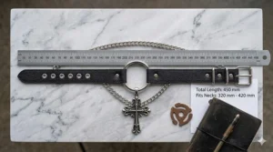 A black leather choker with chain shown next to a ruler to indicate width and length.