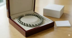 The Tahitian black pearl necklace from the featured image presented inside a premium, dark wood luxury gift box.
